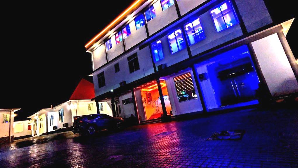 Moonlight Hotel lit up after dark, seen from the forecourt